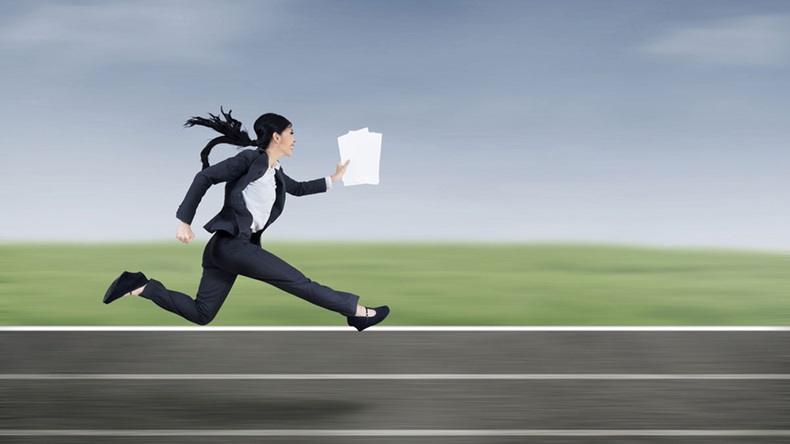 The young beautiful businesswoman runs by holding business paper - Image 
