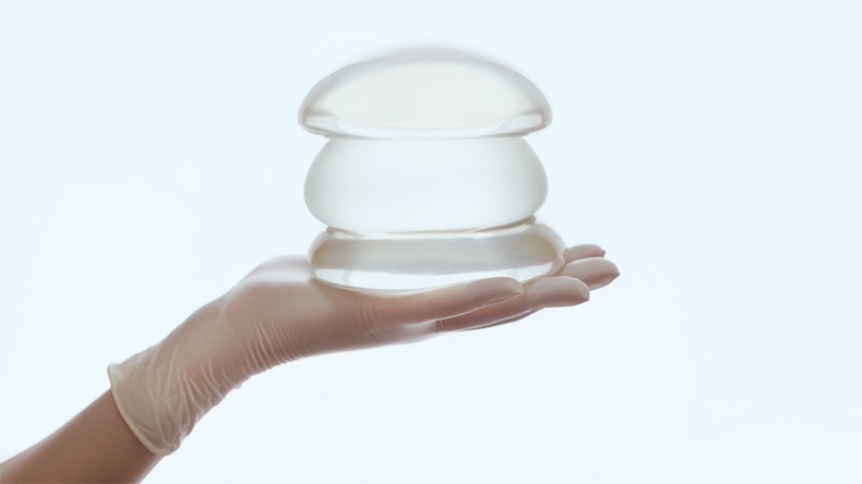 Silicone breast implant on hands - Image 