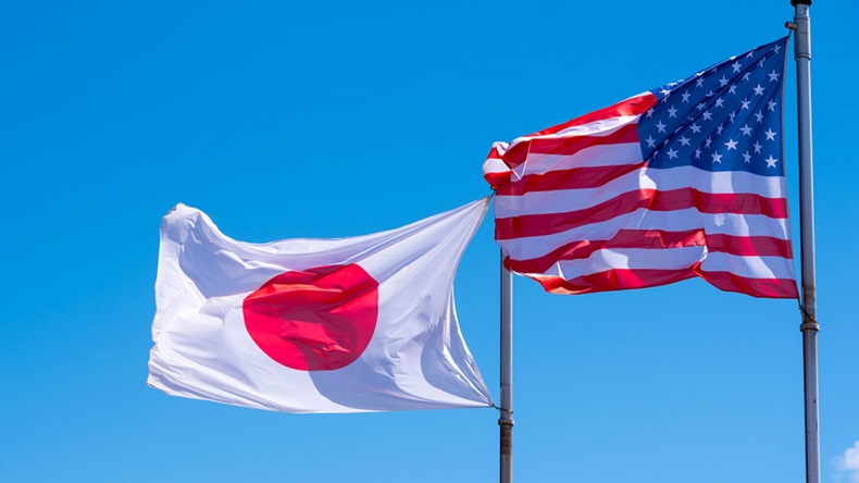 American and Japanese Flags waving against blue Sky