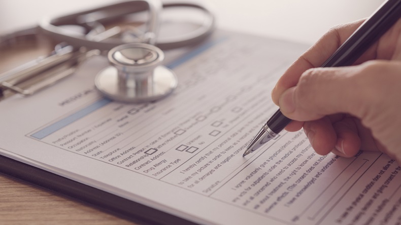 closeup pen in hand's doctor notes data on medical document. - Image 