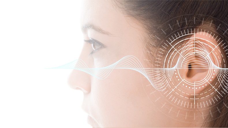 Hearing test showing ear of young woman with sound waves simulation technology - Image 