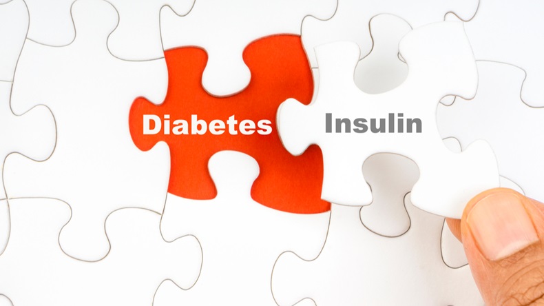 Hand holding piece of jigsaw puzzle with word DIABETES INSULIN. Selective focus - Image 