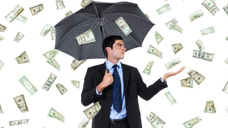 Stock image of businessman with umbrella and falling money - Image 