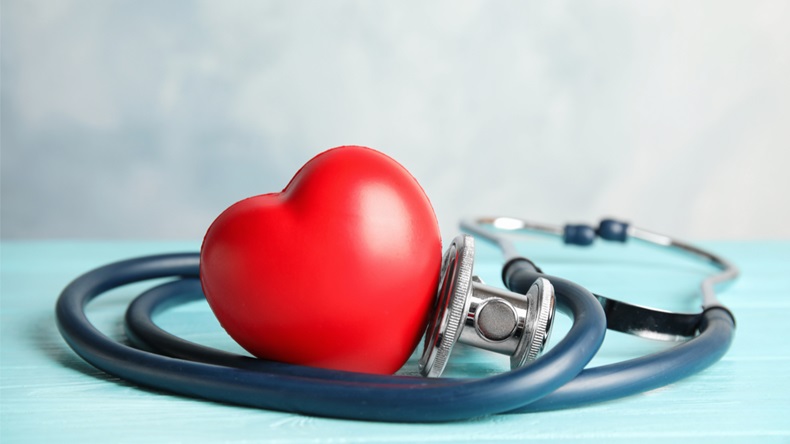 Stethoscope and red heart on wooden table. Cardiology concept - Image 