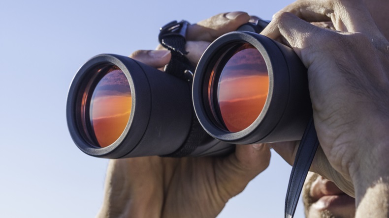 A man looking through the binoculars 