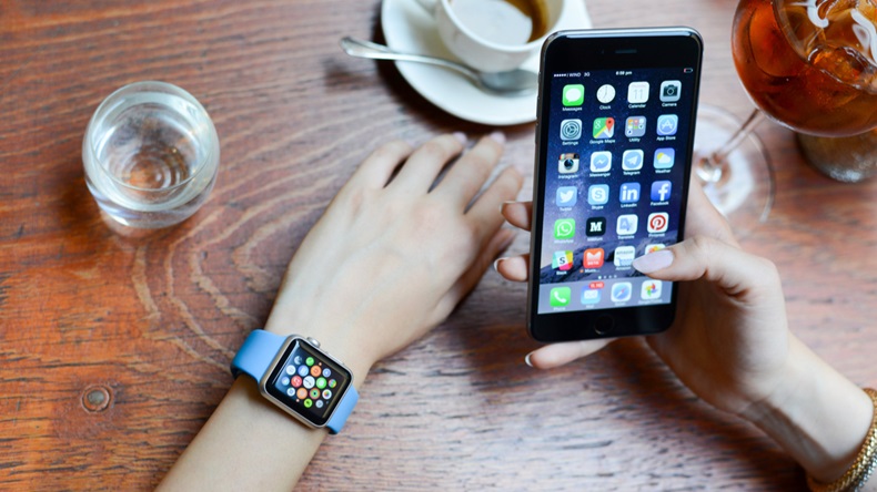 girl wears the apple watch while using the iphone 6