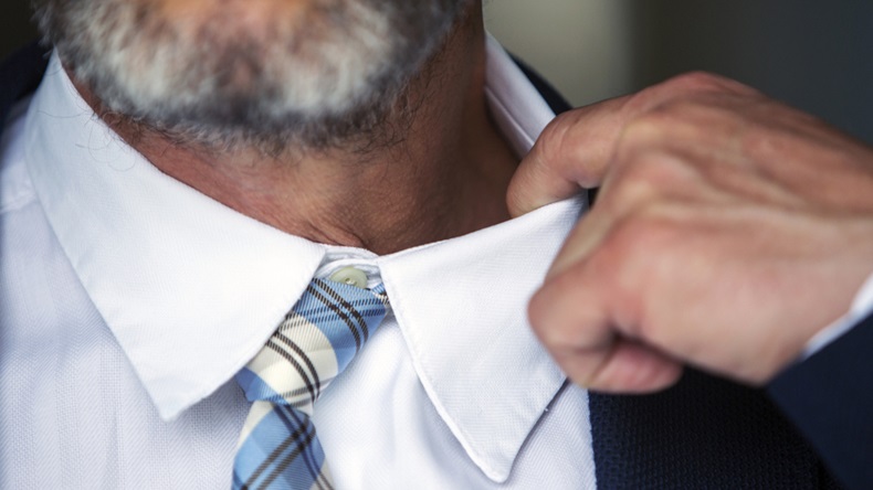 closeup of businessman loosens his shirt
