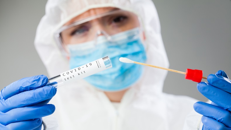 Medical healthcare technologist holding COVID-19 swab collection kit, wearing white PPE protective suit mask gloves, test tube for taking OP NP patient specimen sample,PCR DNA testing protocol process