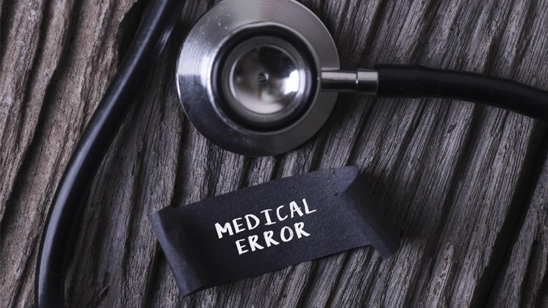 Medical Concept- MEDICAL ERROR word written on label tag with Stethoscope on wood background
