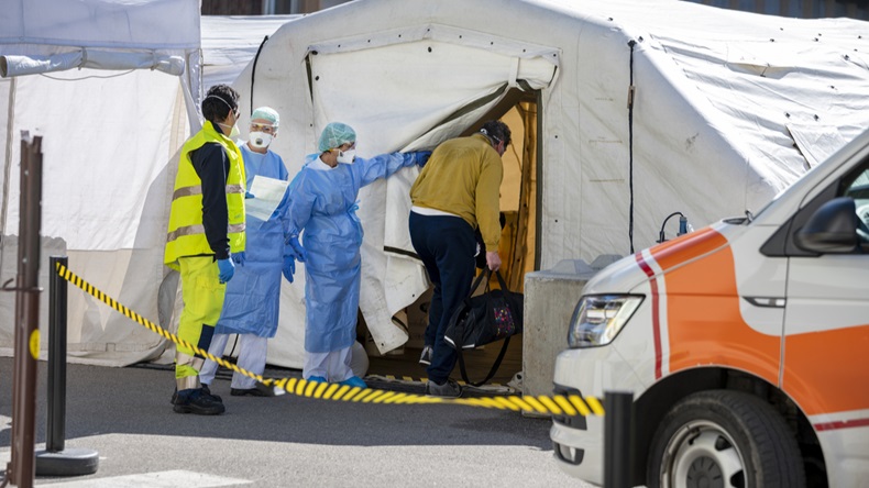 Alert pandemic Covid-19. Triage hospital field tent for the first AID, a mobile medical unit for patient infected with Corona Virus. Doctors with protective masks check the patiences at the entrance.