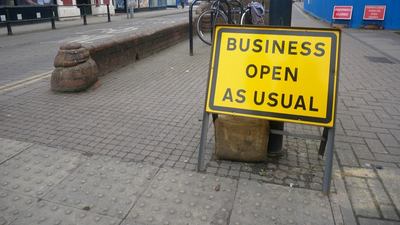 'Business open as usual' sign on British street showing concept of economic recovery