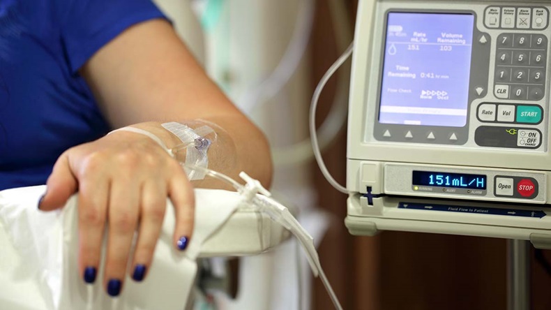 Infusion pump feeding IV drip into patients arm.