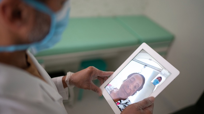 Doctor talking to a patient using digital tablet