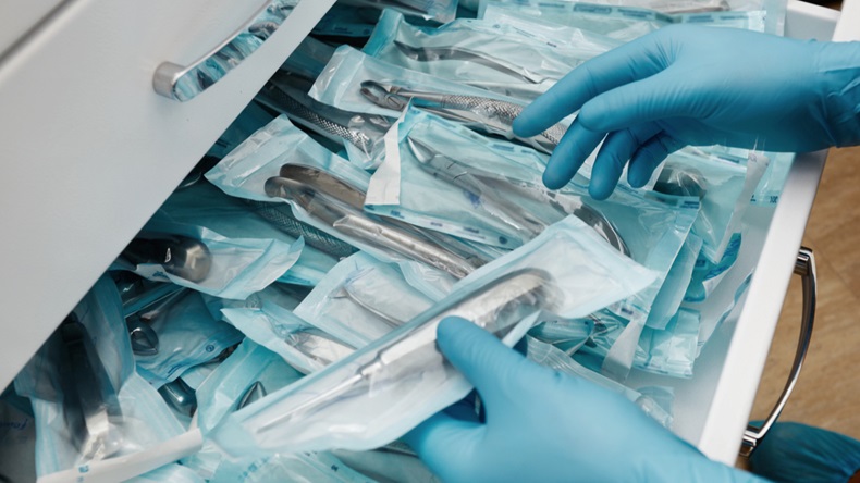 Medical laboratory technician holding a set of sterile disposable instruments