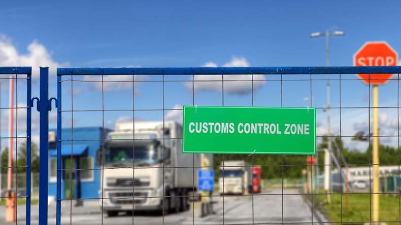 Trucks pass through checkpoint at a Customs logistics terminal.