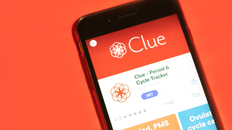 The logo screen of the Clue period tracker is seen against a red background. 