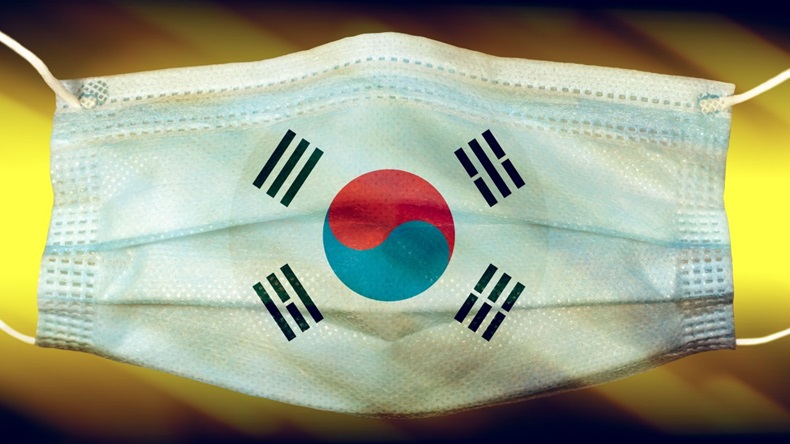 Korean flag printed on disposable paper face mask against a dark background.
