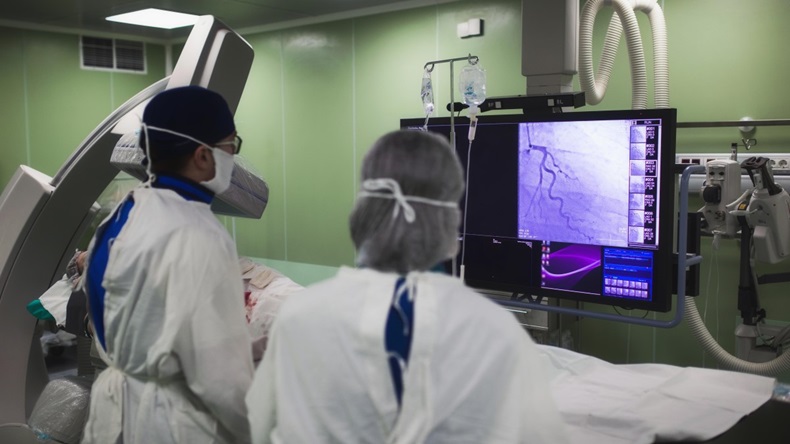 Physicians monitoring stent procedure. 