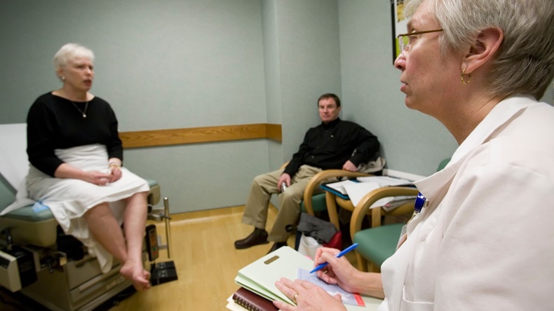 A research nurse talks to a patient participating in a clinical trial of a new cancer treatment