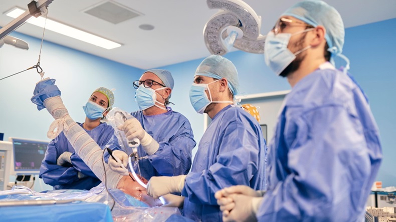 Surgeons with endoscope equipment perform a shoulder arthroscopy.