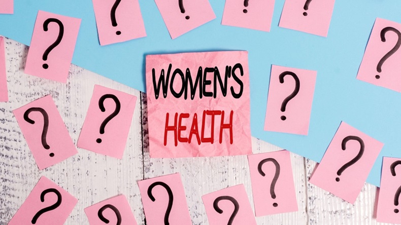 The words "Women's Health" written on pink paper, surrounded by question marks.