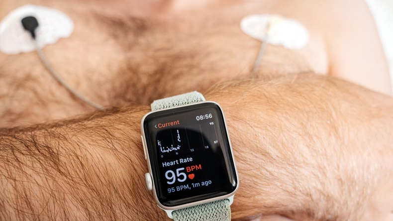 A man with an Apple Watch on his wrist also wearing a heart monitor