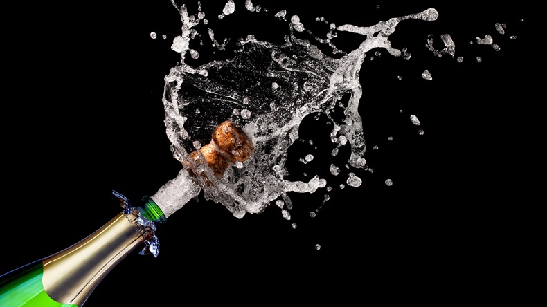 popping champagne on black background