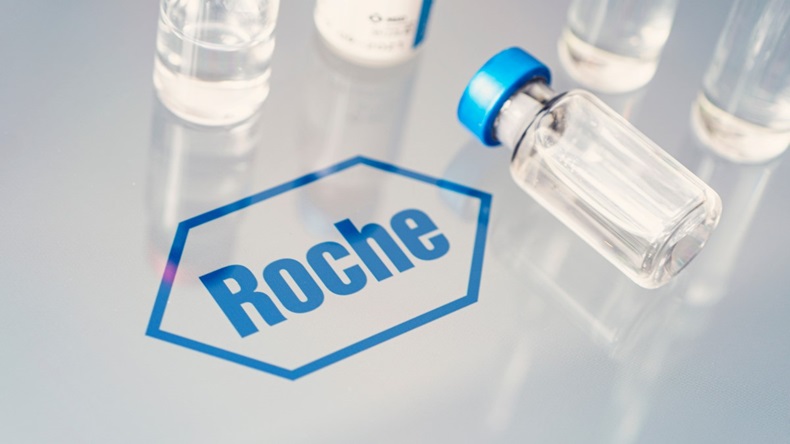 Vials of liquid on a white table with the Roche logo in blue.