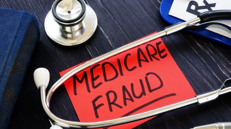 Red paper that says "Medicare fraud" with a stethoscope and some papers.