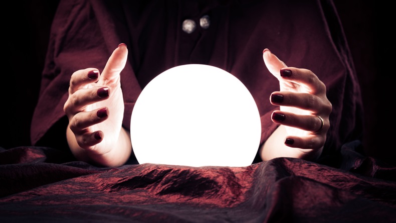 Fortune teller's hands surrounding crystal ball