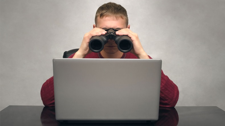 Business man is looking for new ideas. Man searching something in internet looking at laptop through binoculars. Find and search. Online shop.