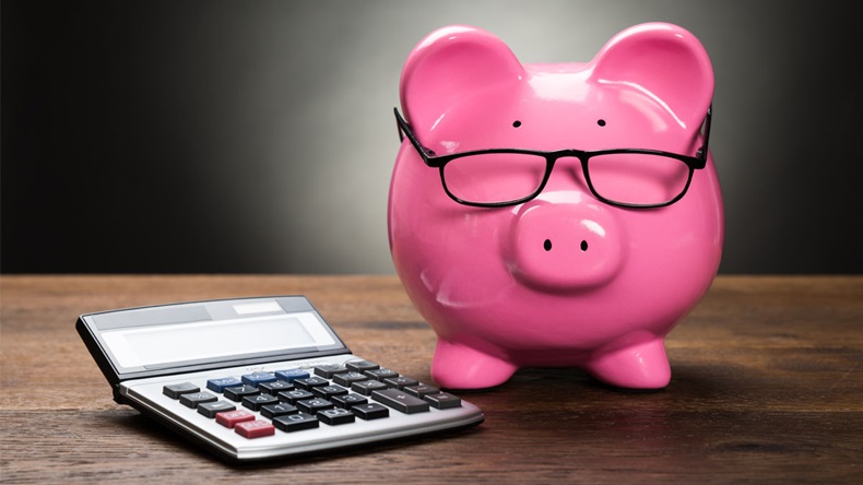 Pink Piggybank With Calculator On Wooden Table