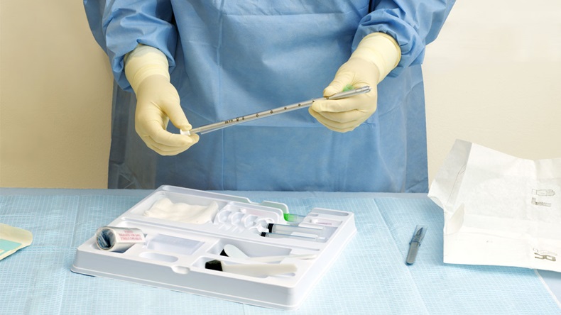 Nurse prepares a trocar catheter for a surgical procedure.