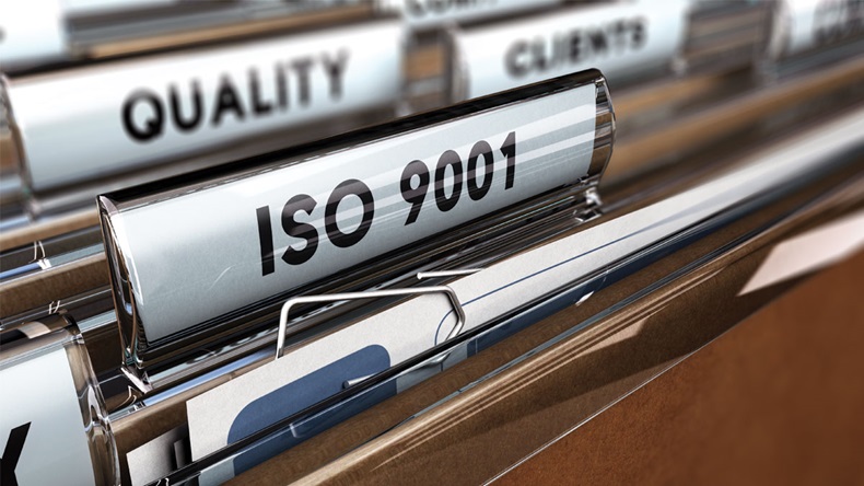 Close up on a file tab with the word ISO 9001, focus on the main text and blur effect. Concept image for illustration of Quality Standards