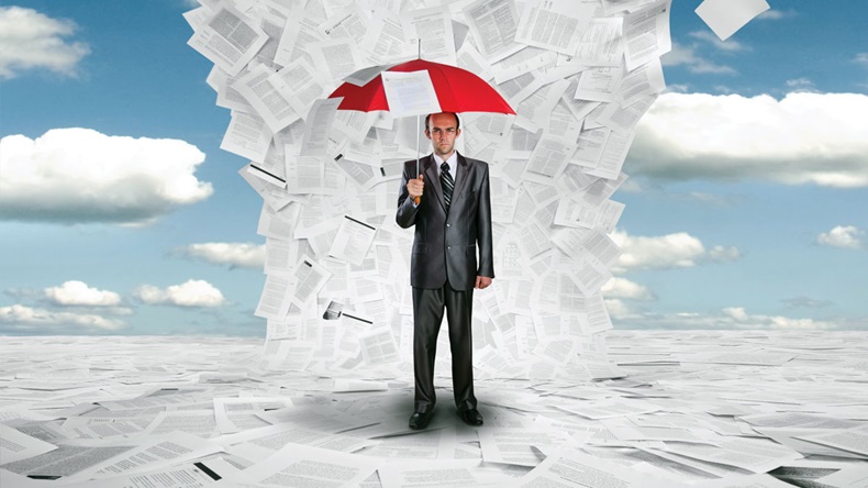 Serious businessman with red umbrella under huge wave of documents